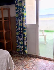 a bedroom with a sliding glass door with a view of the ocean at Apartamentos Calypso in Punta Umbría