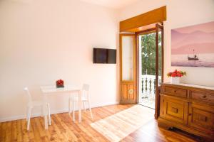 a dining room with a table and chairs and a window at Appartamenti Vistaqua in Baveno