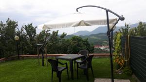 une table et des chaises sous un parasol sur l'herbe dans l'établissement La casina negli orti, à Arcola