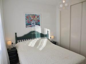 a bedroom with a white bed with two tables and a painting at Rubino in Calpe