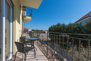 a balcony with two chairs and a table at Guesthouse Bencun Medulin in Medulin