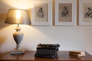 una lámpara sentada en una mesa junto a una vieja máquina de escribir en Locanda I Girasoli, en Misano Adriatico