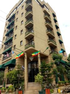 a large apartment building with stairs in front of it at Sherar Addis Hotel in Addis Ababa