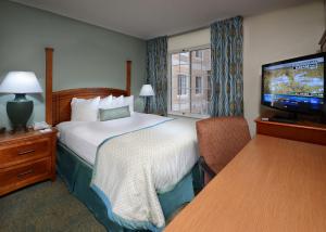 ein Hotelzimmer mit einem Bett und einem Flachbild-TV in der Unterkunft Staybridge Suites Raleigh-Durham Airport-Morrisville, an IHG Hotel in Morrisville