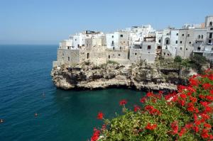 a group of buildings on an island in the water at Versomare in Polignano a Mare