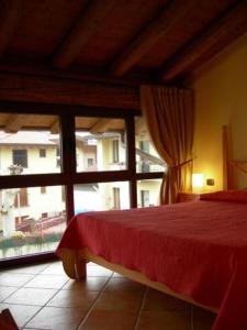 a bedroom with a red bed and a large window at Locanda dell'Oca Bianca in Como