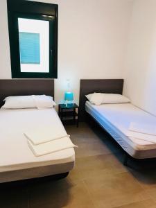 two beds in a room with a window at Apartamentos Deluxe Benicasim in Benicàssim