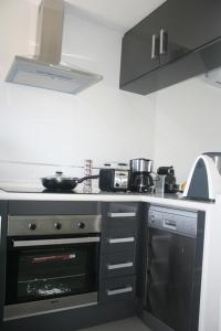 a kitchen with a stove top oven next to a microwave at OasisBeach Penthousse la Zénia in Playas de Orihuela