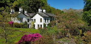 een groot wit huis aan de zijkant van een heuvel bij Foxghyll Country House in Ambleside