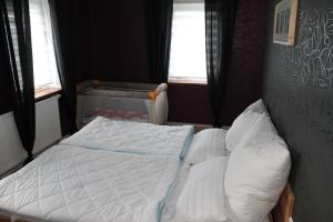 - un lit dans une petite chambre avec 2 fenêtres dans l'établissement Landidyll, à Breitenbrunn/Erzgeb. 41 autres photos