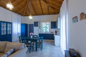 ein Wohnzimmer und eine Küche mit einem Tisch und Stühlen in der Unterkunft Kefalonia Ammos Villa in Lixouri