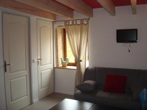 a living room with a couch and a window at Chambre d'hôtes Les Plaisances in Saint-Julien