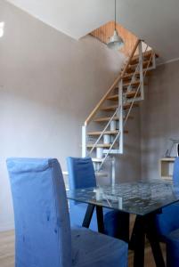 a dining room with a glass table and blue chairs at San Rocco in Turin