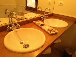 a bathroom counter with two sinks and a mirror at Casa Fidela in Lomeña