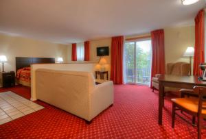 a hotel room with a bed and a couch and a desk at Ogunquit Tides in Ogunquit