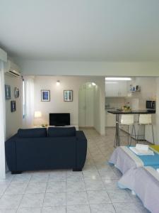 a living room with a blue couch and a kitchen at Ocean Blue Apartments in Paphos