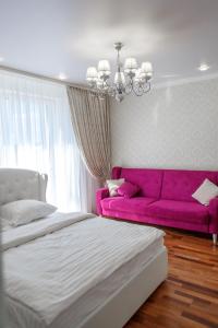a bedroom with a bed and a pink couch at Apartment Status in Kaliningrad