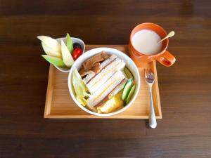 a sandwich and a cup of coffee on a wooden tray at Spring Tree in Luodong