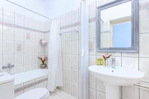 a bathroom with a sink and a toilet and a mirror at Agora Apartment in Limenas +25 photos