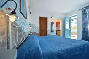 a bedroom with a blue bed with a blue bedspread at Azzurromare Residence in Procida