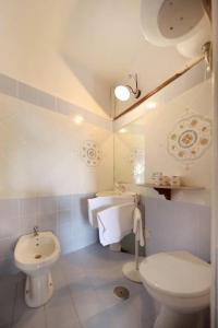 a white bathroom with a toilet and a sink at Azzurromare Residence in Procida