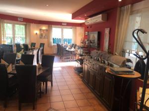 ein Restaurant mit Tischen und Stühlen in einem Raum in der Unterkunft Hotel Mylos in Sittensen