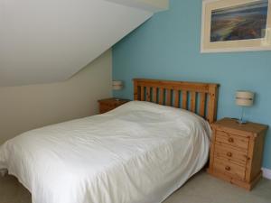 a bedroom with a white bed and two night stands at Hill Cottage in Newchurch