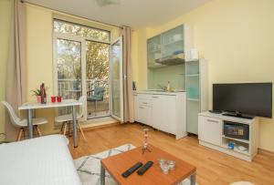 ein Wohnzimmer mit einem Sofa und einem TV in der Unterkunft Studios Lulic in Makarska