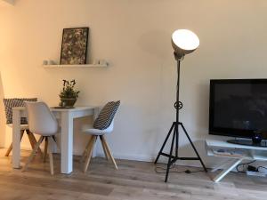 Zimmer mit einem Schreibtisch, einem TV und einer Lampe in der Unterkunft Hamptons No.2 in Scharbeutz