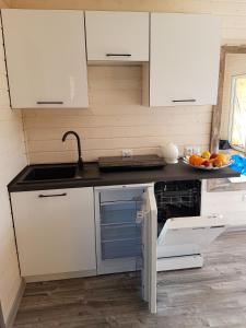 a kitchen with white cabinets and a sink at Noclegi Beata in Dąbki