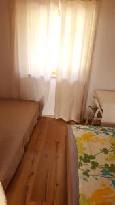 sypialnia z łóżkiem, oknem i drewnianą podłogą w obiekcie Römerstraße 10 KG, Appartement Inntal w mieście Innsbruck