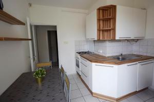 eine Küche mit weißen Schränken und einem Waschbecken in der Unterkunft Optimum Home in Pécs