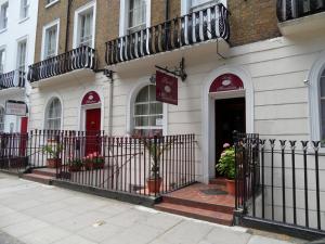 un bâtiment avec une clôture devant lui dans l'établissement Hotel Meridiana, à Londres