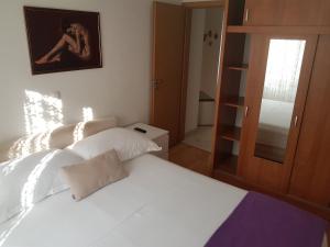 1 dormitorio con 2 camas blancas y espejo en Apartment Varos, en Zadar