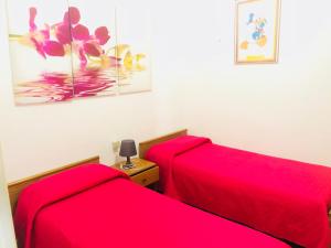ガリポリにあるAppartamenti Antonaciの赤いシーツが備わるドミトリールームのベッド2台