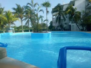 una gran piscina con palmeras frente a un edificio en Nirvana Hotel - Cancun Hotel Zone, en Cancún