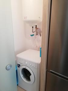 una lavatrice e un lavandino in una piccola stanza di Luminoso Apartamento Con Parking a Santiago de Compostela