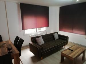 un soggiorno con divano e tavolo di Luminoso Apartamento Con Parking a Santiago de Compostela