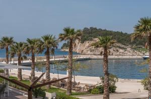 a view of a beach with palm trees at Studios Lulic in Makarska