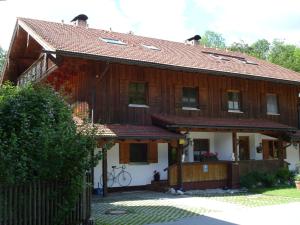 ein großes Holzhaus mit einem Zaun in der Unterkunft Buchwinklblick in Aschau im Chiemgau