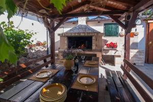 d'une terrasse avec une table à manger extérieure et une cheminée. dans l'établissement Apartmani Luka, à Vir