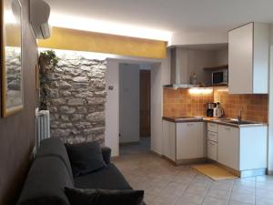 ein Wohnzimmer mit Couch und Küche in der Unterkunft Appartamento La fontanella in Malcesine