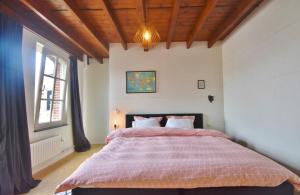 una camera da letto con un grande letto con un piumone rosso di Enroute367 a Varsenare