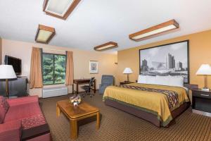 um quarto de hotel com uma cama grande e um sofá em Super 8 by Wyndham Sun Prairie/Madison E em Sun Prairie