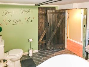 a bathroom with a sliding barn door and a toilet at Co-ed Dorm with Fantastic Patio! in Ewing