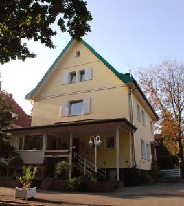 ハノーファーにあるFinkenhof - Haus Meersmannuferの緑の屋根の大きな黄色の建物