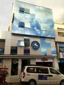 una furgoneta blanca estacionada frente a un edificio en Hotel Cielo Tarapoto, en Tarapoto