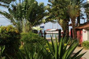 a group of people walking down a street with palm trees at Beto´s Pousada in Abraão