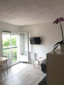 un soggiorno con un divano e una TV di Les Hameaux de Provence - Piscine et place de Parking privée - Accès plage et sentier du littoral a Bandol