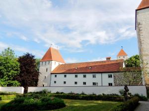 un gran edificio blanco con techo rojo en Gästehaus Mälzerei auf Schloss Neuburg am Inn, en Neuburg am Inn